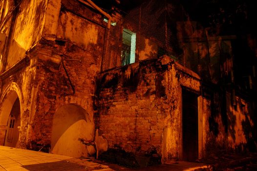 Night shot of an old rundown brick house