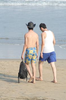 Two men walking on beach
