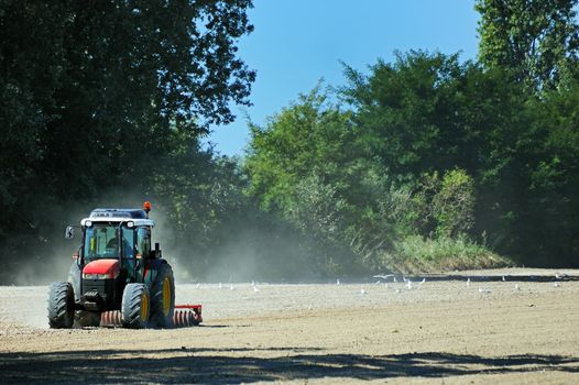 Tractow plowing field in a sunny day