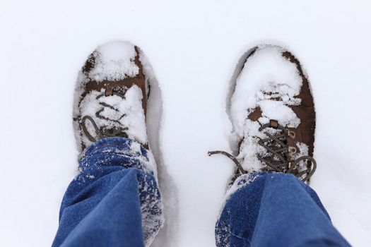 standing in the snow, wearing jeans and boots, picture taken from photographer's point of view