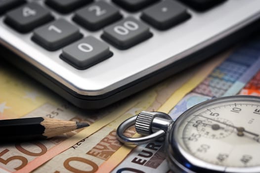 Euro bills,chronometer and calculator close up