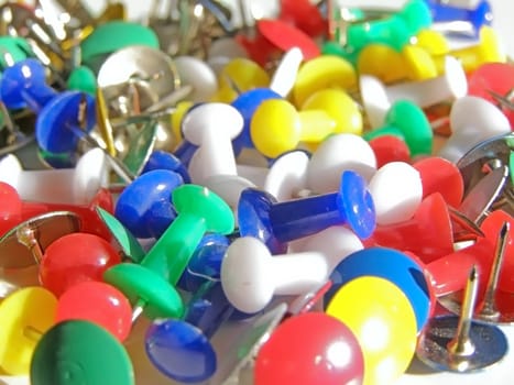 scattered multicolored thumb tacks and pins