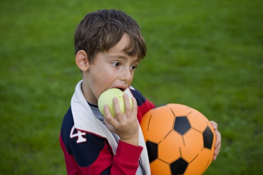 Beautiful boy with apple and ball