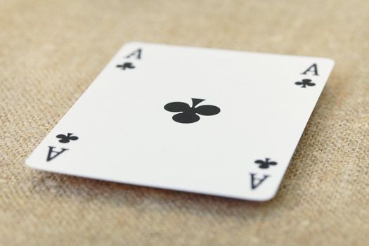 The ace of spades lies on a table covered with a fabric