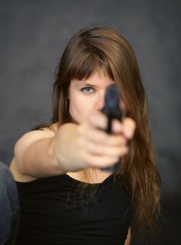 The woman aiming in the enemy from a pistol