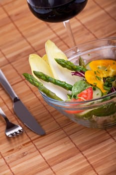 glass bowl of fresh salad with green asparagus