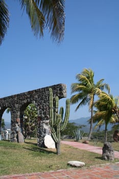 Arches and palm trees with cactus
