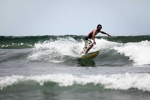 Young men - the surfer in ocean. Bali. Indonesia