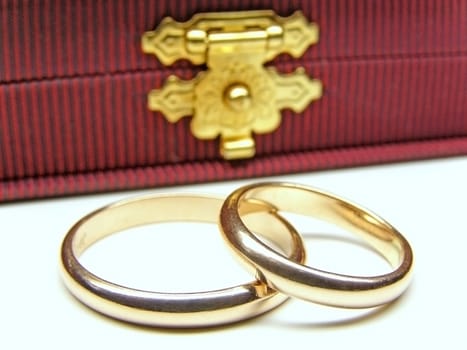 two golden wedding rings against elegant case  