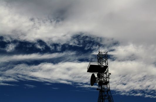 telecommunications station with a blue cloudy sky background
