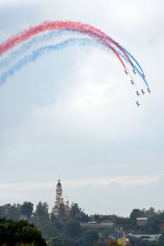 Manmade rainbow above Orthodox church. Aerobatics on Russian  airshow.