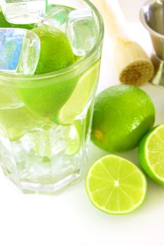 Caipirinha cocktail with green lemon and ice cubes
