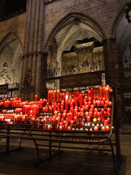 Multitude of glowing candles in beautiful gothic cathedral in Barcelona (Spain).