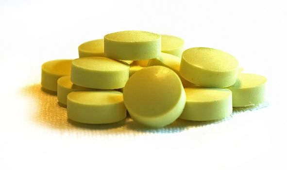 handful of yellow pills on a lid