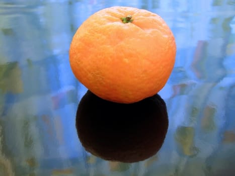 Single orange mandarin against the blue background     