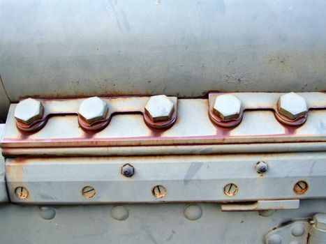 Screws, nuts and bolts on an industrial close-up of an old machine.