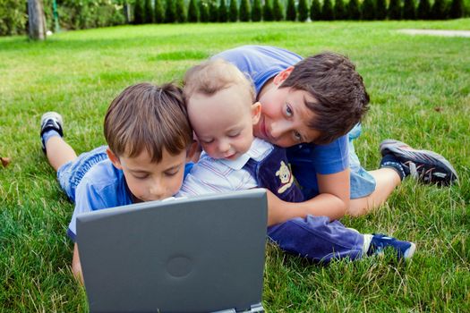 Three cute brothers study on computer 