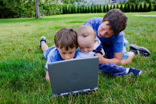 Three cute brothers study on computer 
