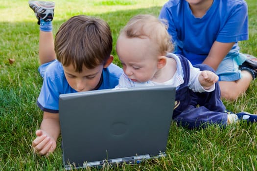 Three cute brothers study on computer 