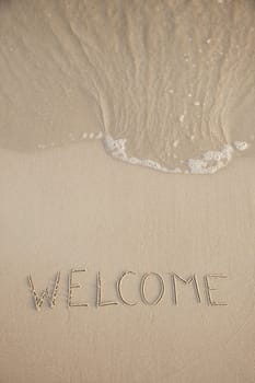 Welcome written in the beach