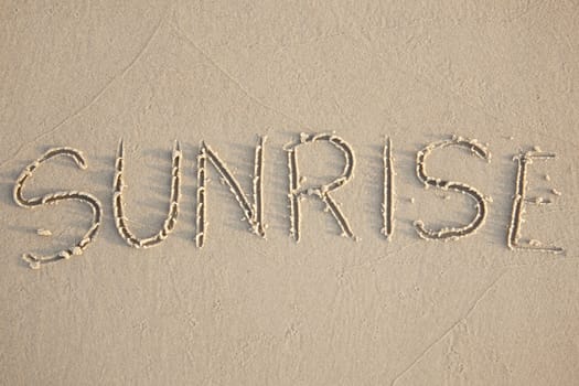 Sunrise written in the beach