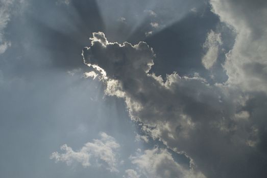 Sunrays spilling around a cloud