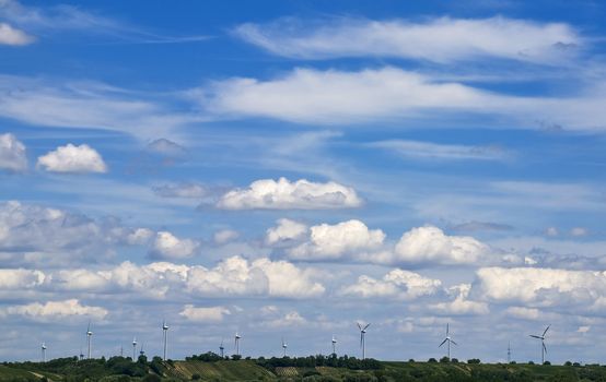 Many wind engines in front of a dynamic sky