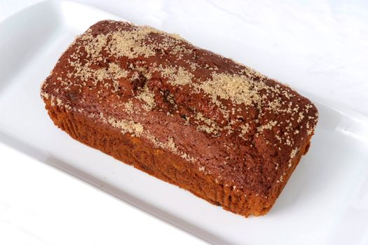 Mass-produced catering trade ginger cake on a white background