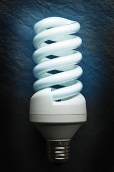 Fluorescent light bulb on a grey background.