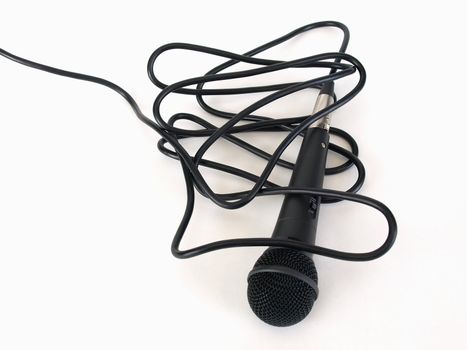 Studio microphone isolated on a white background with cord bunched and trailing off to the side.