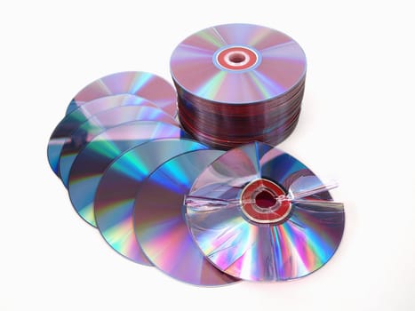A stack of compact discs with one in front, broken and bent, over a white background.