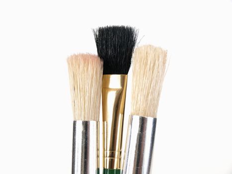 A trio of Brush Tips, two white, one black, over a white background.