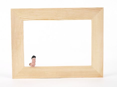 A cute EarthWerm in a bowler hat sits on the edge of a blank tan wood frame over a white background. Photographer holds copyright on figurines.