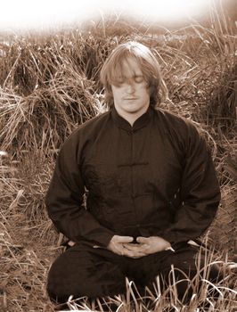 a young man meditates in natural setting while seeking peace and enlightenment.