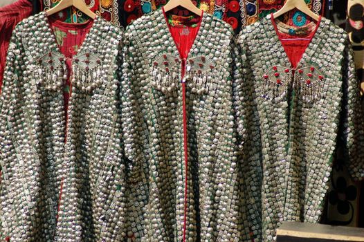 Three chain-mail capes hanging on clothes hangers in Camden Market