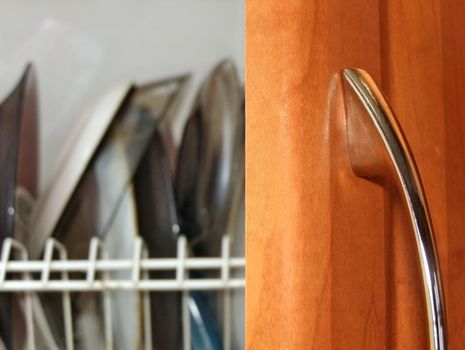 Kitchen plates over open wooden door with metallic handle