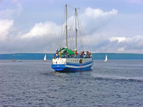 yacht with passengers against the coastline