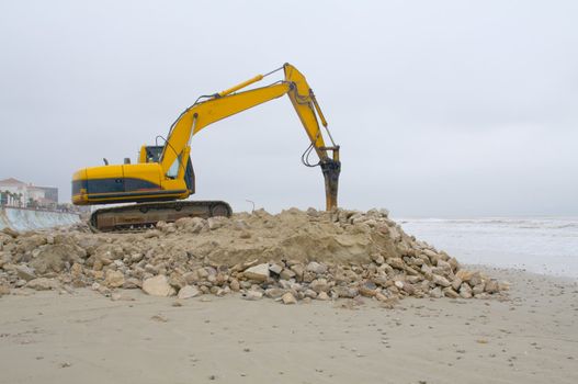 Heavy equipment moving sand and rocks on the beach