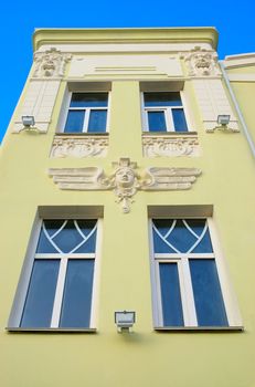 facade of the building with decorations from gypsum in the manner of feminine head