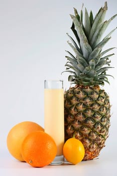 Fresh tropical fruit with juice and milk in a high glass glass.