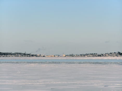 Tranquil winter lake skyline with the blue sky and town