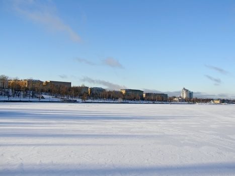 Tranquil winter lake skyline with the blue sky and town