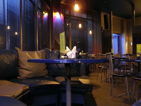 Cafe night interior with tables and sofa
