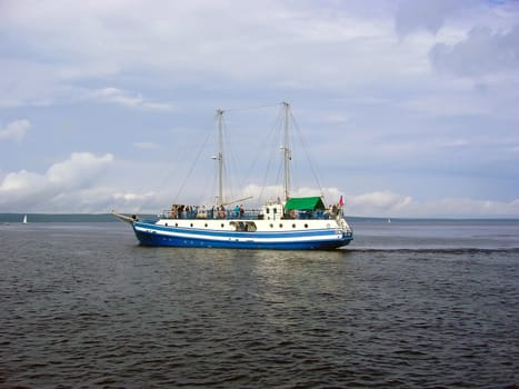 Single yacht on the sea waves under clouds