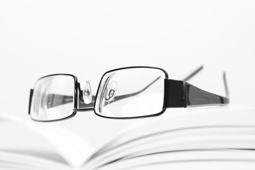 Eyeglasses on open book in black and white