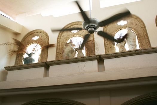 upscale home with window arches and pottery fan spinning