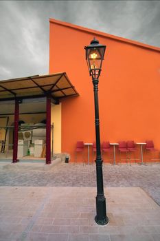 Old lantern in front of orange wall