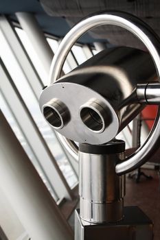 Closeup of modern metal coin-operated binoculars inside viewing tower