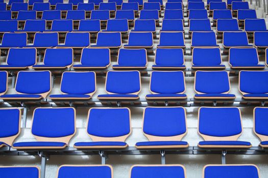 Rows of empty blue stadium seats background