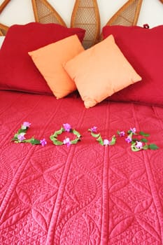 Bed with the word love spelled out with flowers